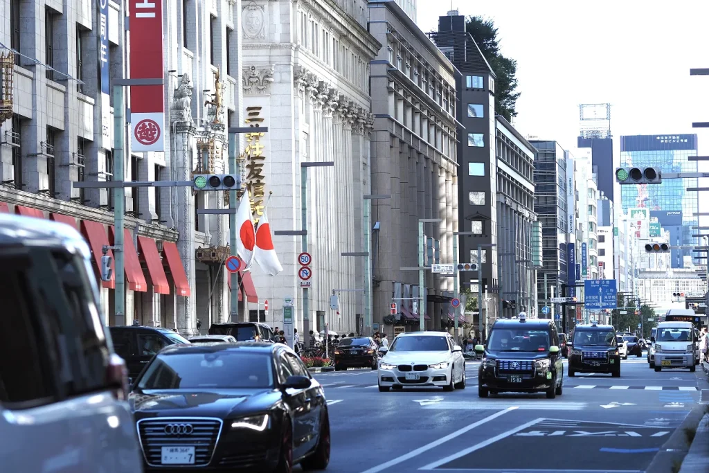 銀座・日本橋エリアの大通りと日本国旗・三越ビル｜日本経済